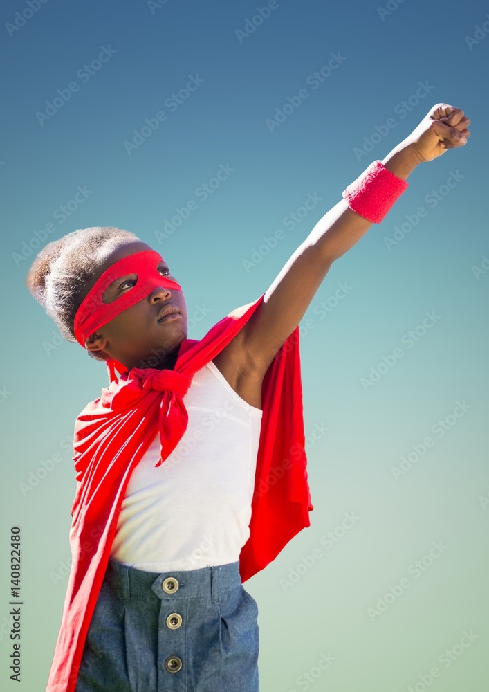 Kid in red cape and mask standing with fist