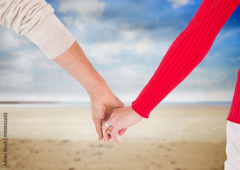 Newly wed couple holding hands on beach