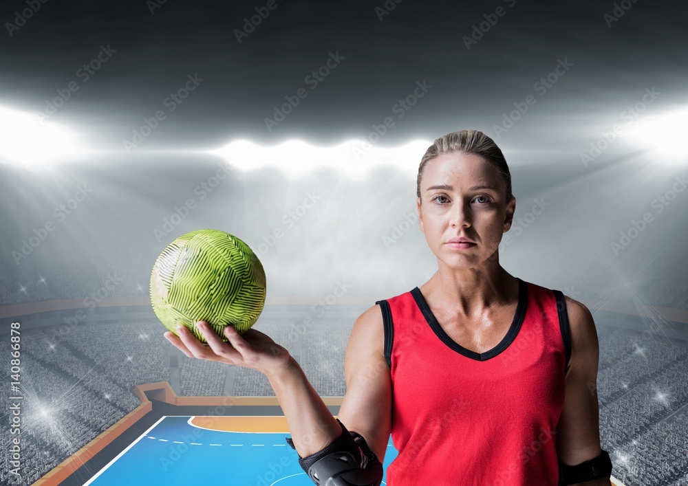 Portrait of a female handball player holding ball in stadium