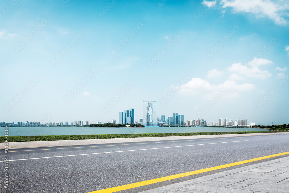 empty road and cityscape of modern city in blue sky