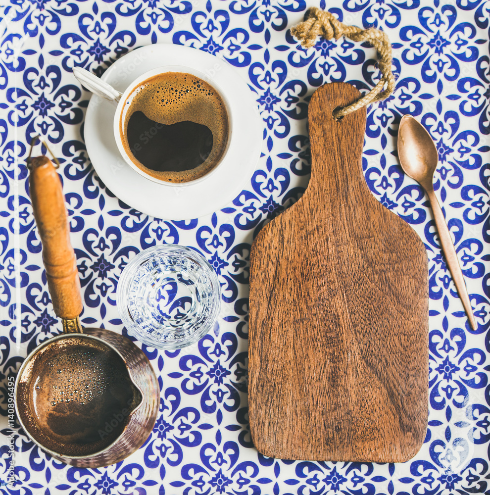 Black Turkish or Eastern style coffee in cup and cezve and wooden board with copy space, oriental Mo