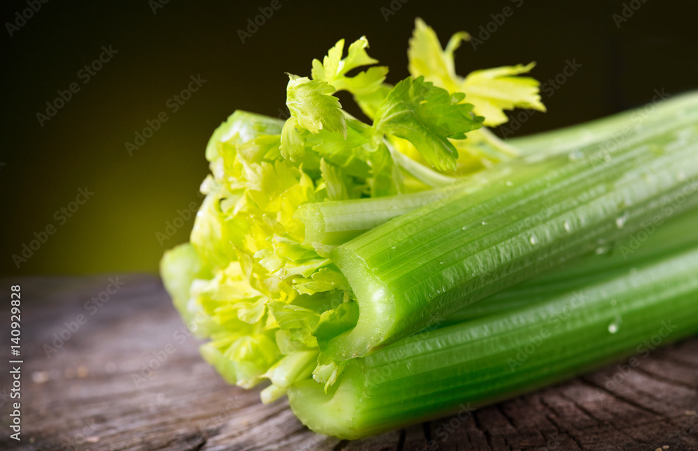 Celery closeup over black background. Leaves and stem of fresh organic green celery