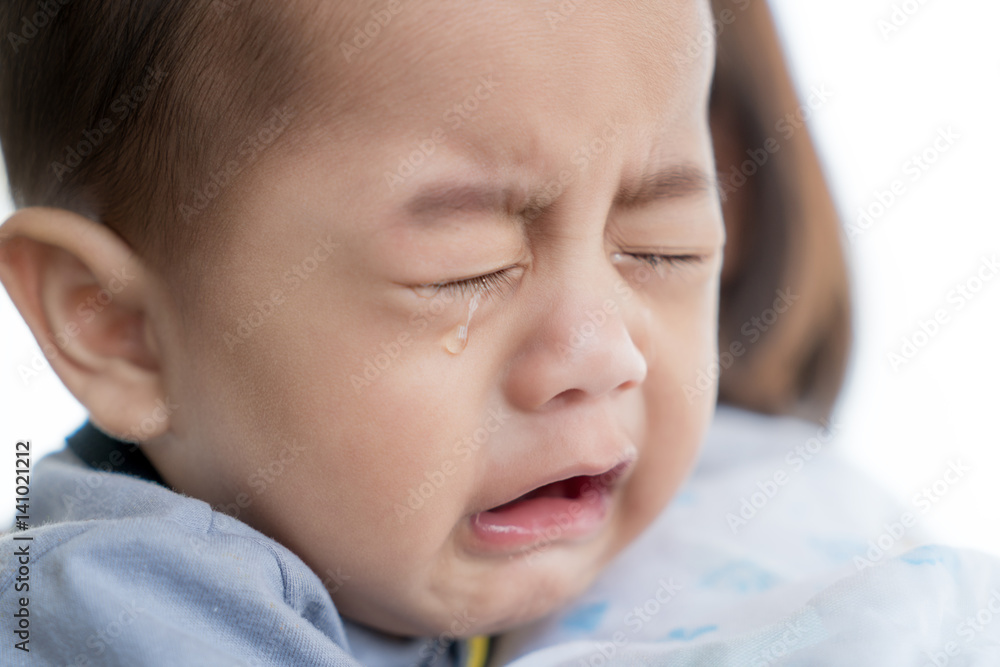 Portrait of 5 months Asian baby boy crying in mother arm.