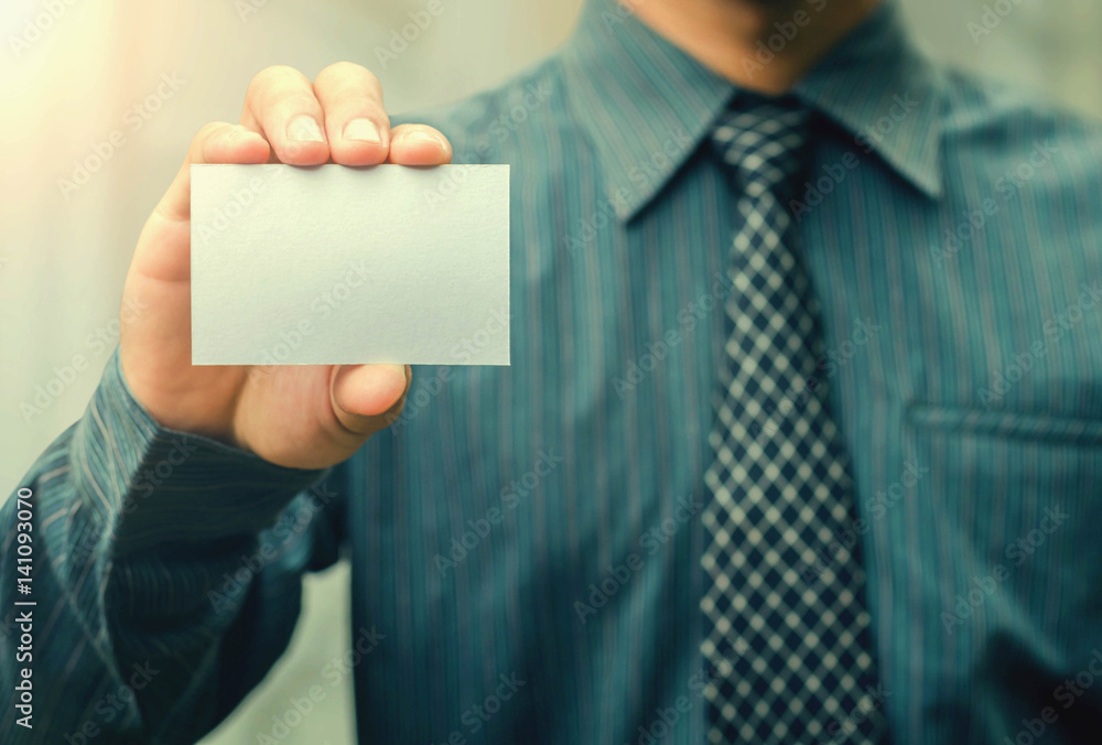 Mans hand showing business card - closeup shot and sunshine