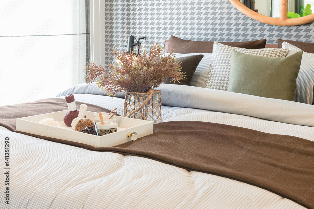 glass vase of plant with wooden tray on luxury bed in luxury bedroom