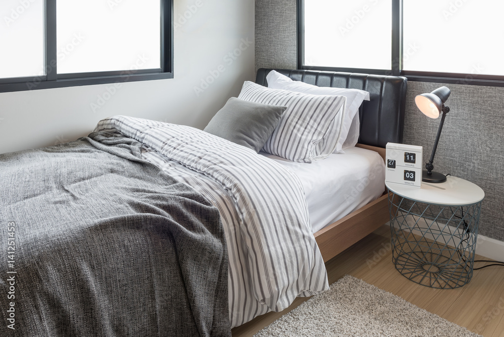 set of pillows with blanket on modern wooden bed in modern bedroom