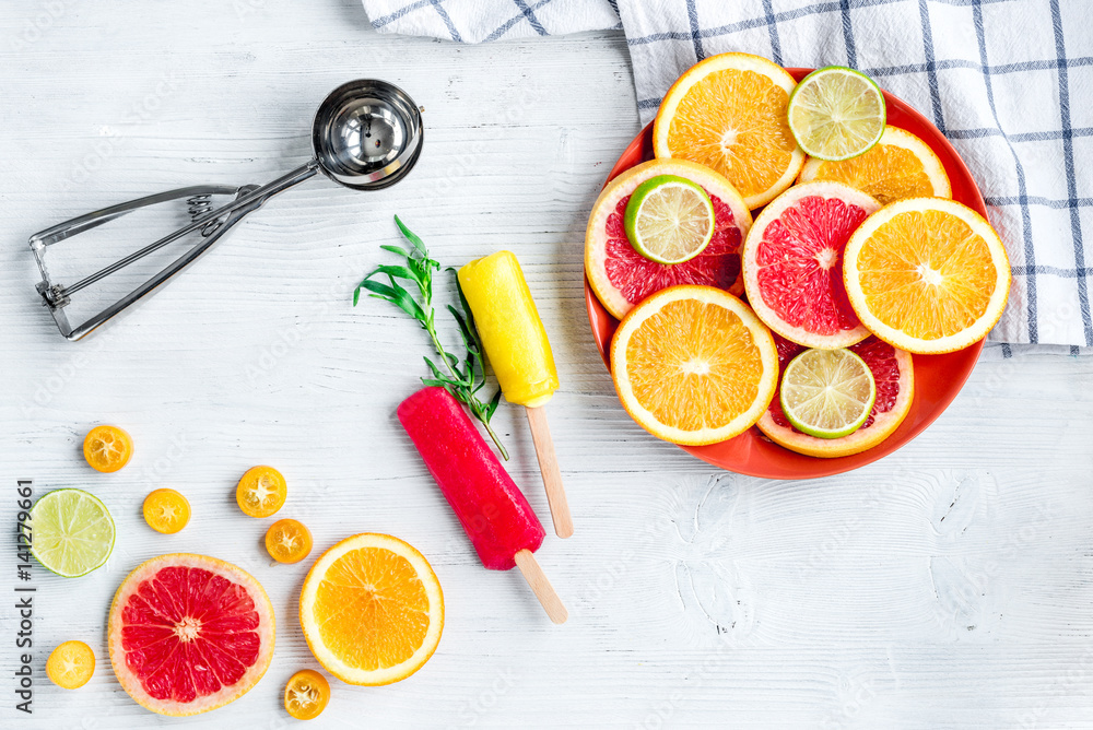 citrus popsicles with fruit slices on stone background top view