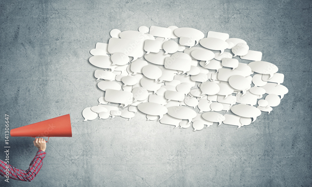 Hand of woman holding red paper trumpet and speech cloud