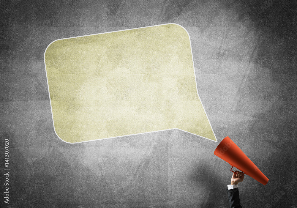 Hand of businesswoman holding red paper trumpet and speech cloud