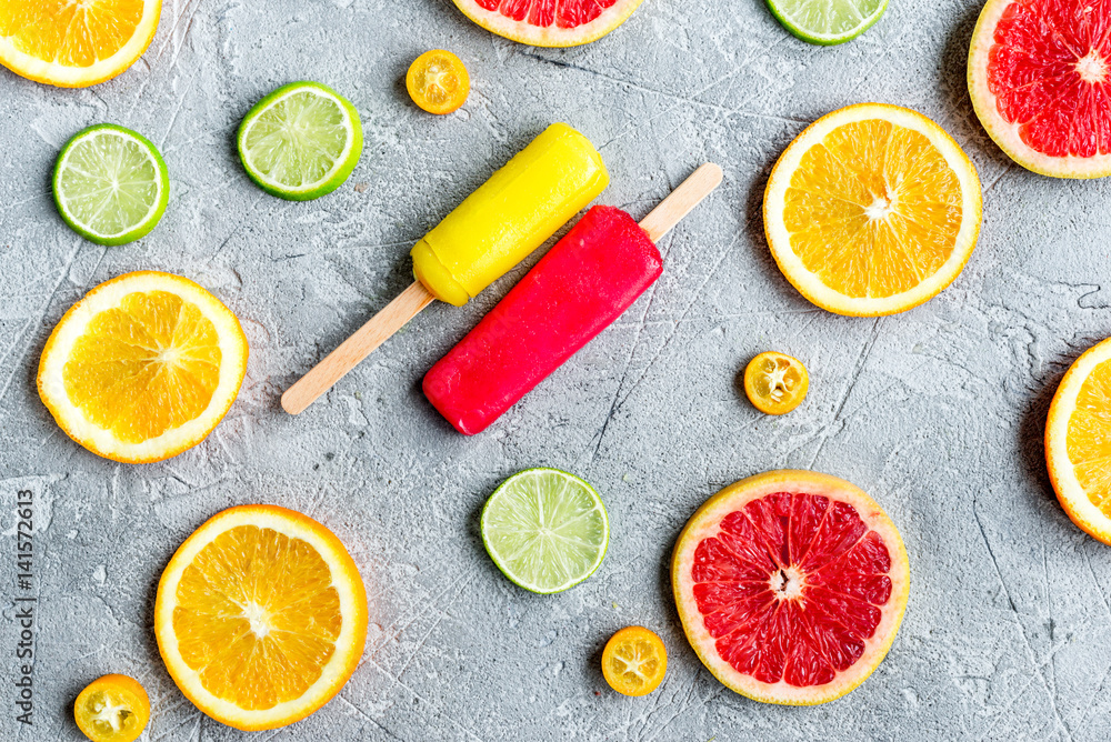 citrus slices with fruit popsicles on table background top view pattern