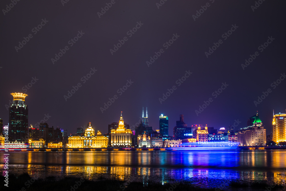 黄浦江上的游船夜景，以黄浦江北部的天际线为背景