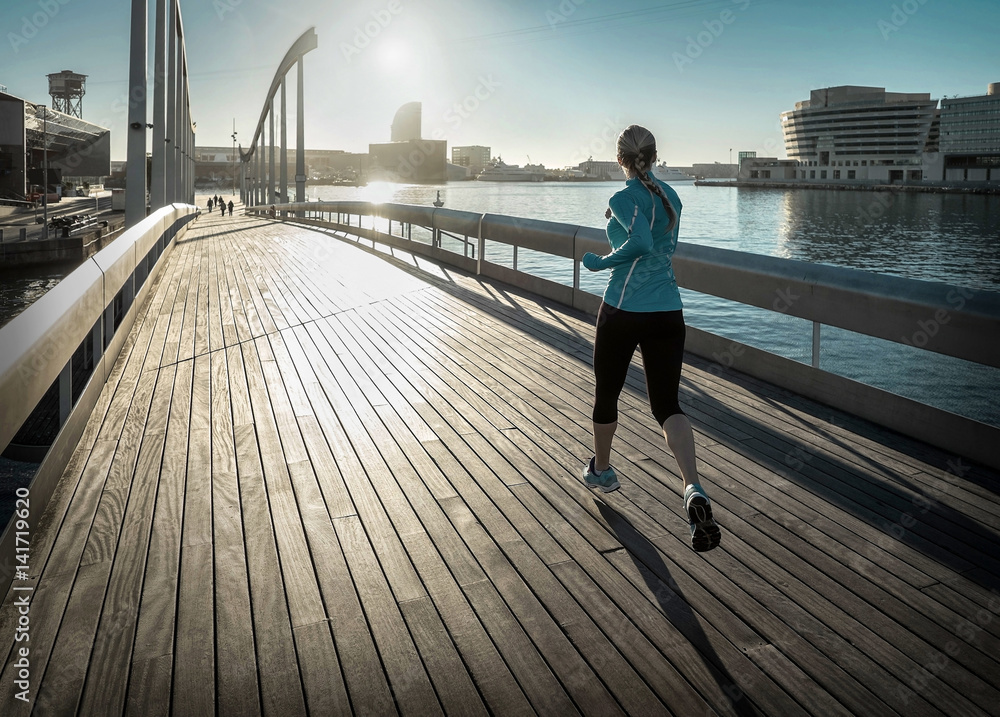 Woman running on the bridge under sunlight.