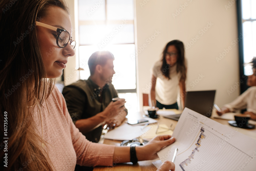 Woman looking at document during meeting in conference room