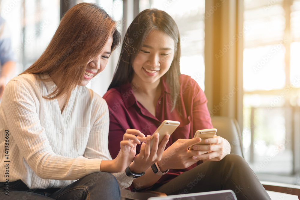 Two woman using smartphone sharing data, iot, internet of things conceptual