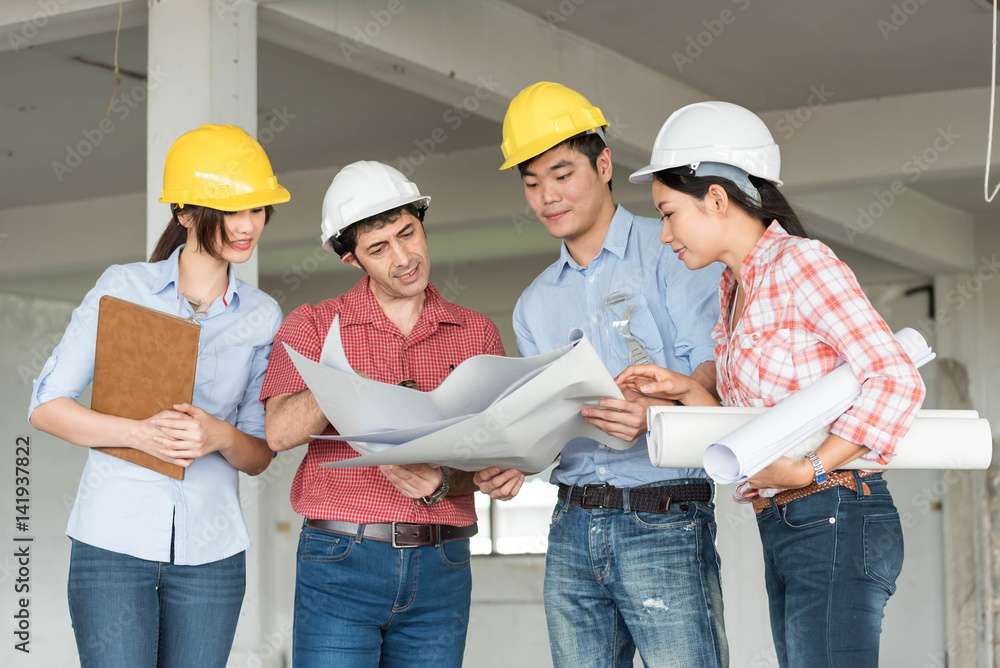 Four construction engineer working in side building plan for renovation, construction engineering co