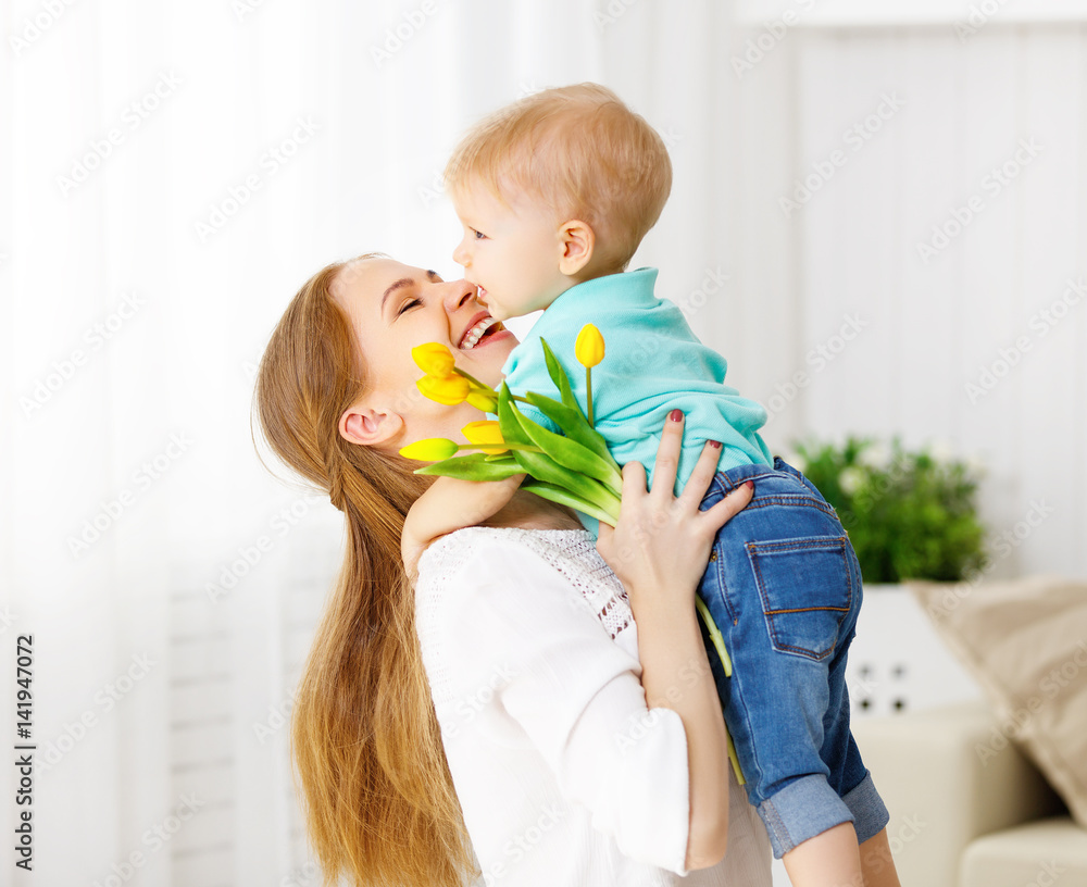 Happy mothers day. Baby son gives flowers for mom