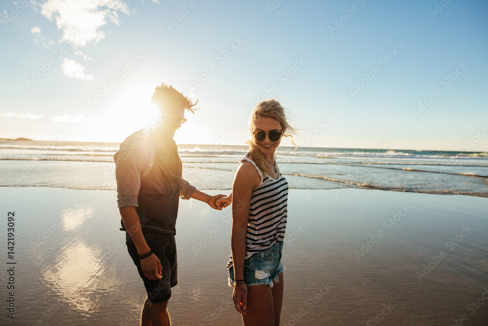 Romantic young couple walking along the sea shore