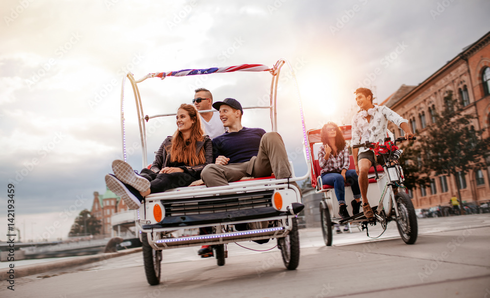 Young people enjoying tricycle ride in the city