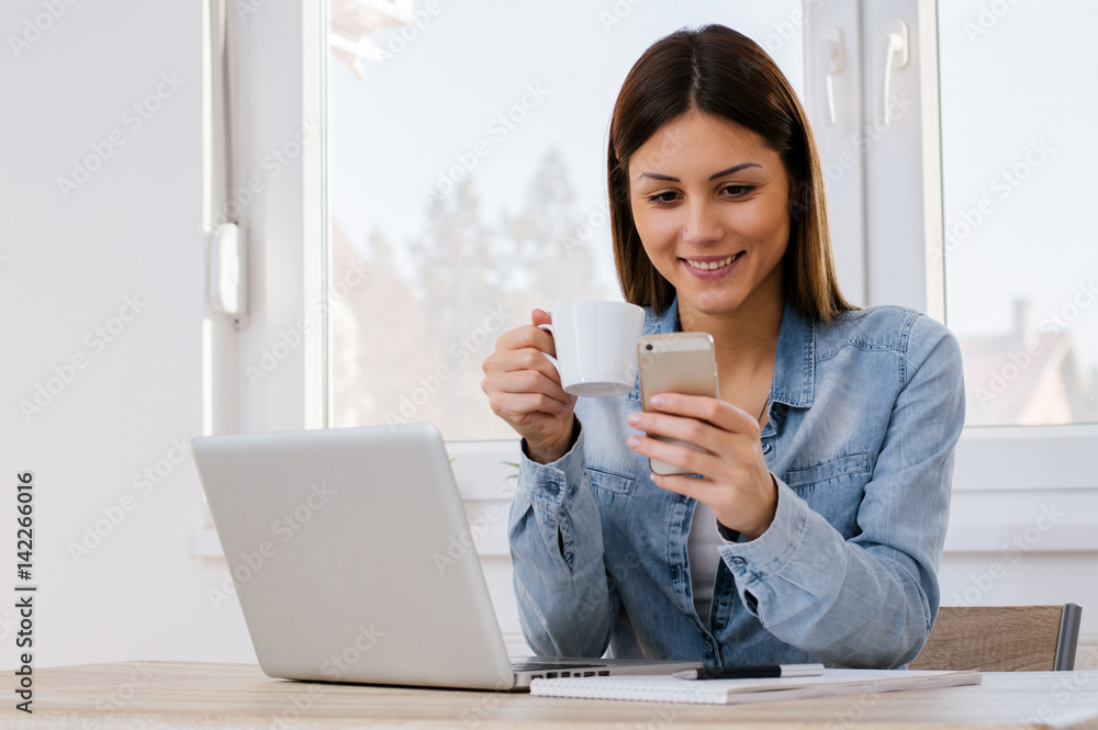 Beautiful girl drinking coffee and texting her boyfriend