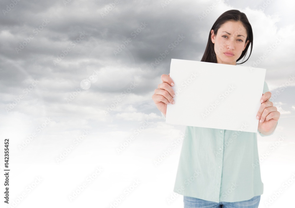 Sad woman holding blank card against clouds