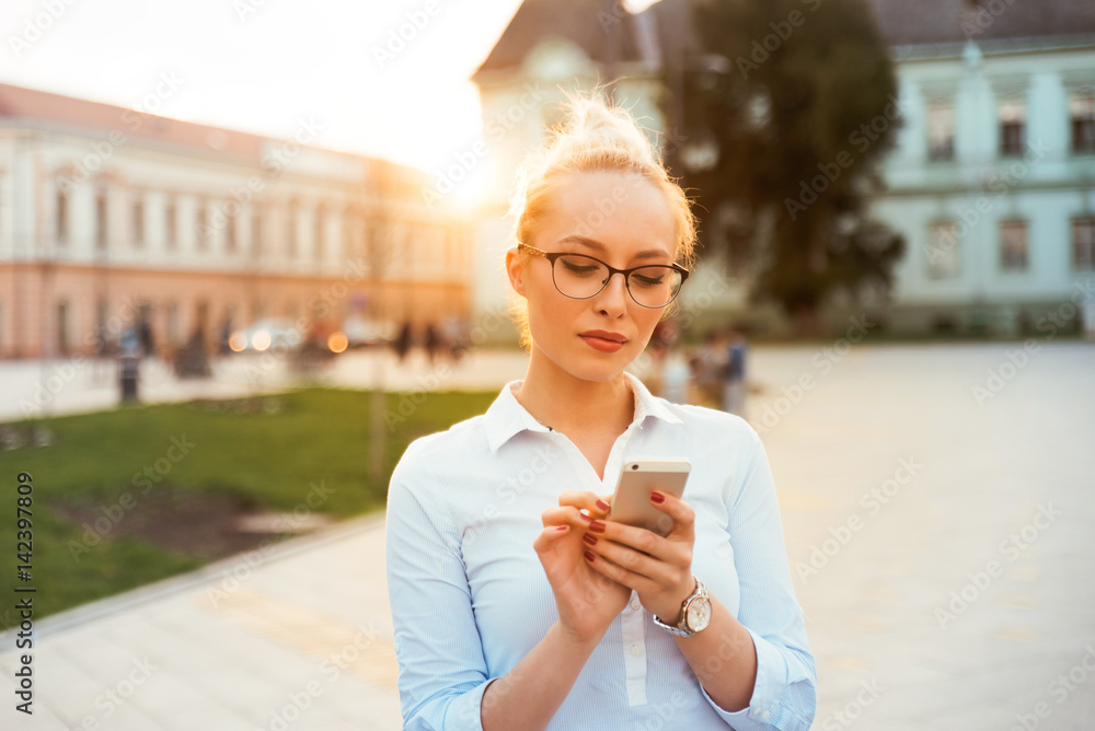 Girl is using her phone in city center