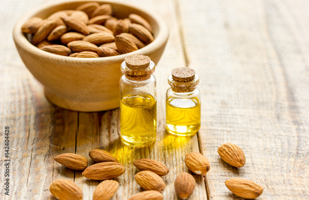 cosmetic set with almond oil on wooden table background