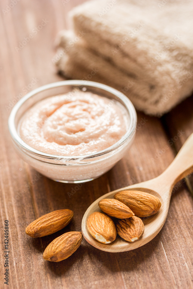 cosmetic set with almond scrub on table background