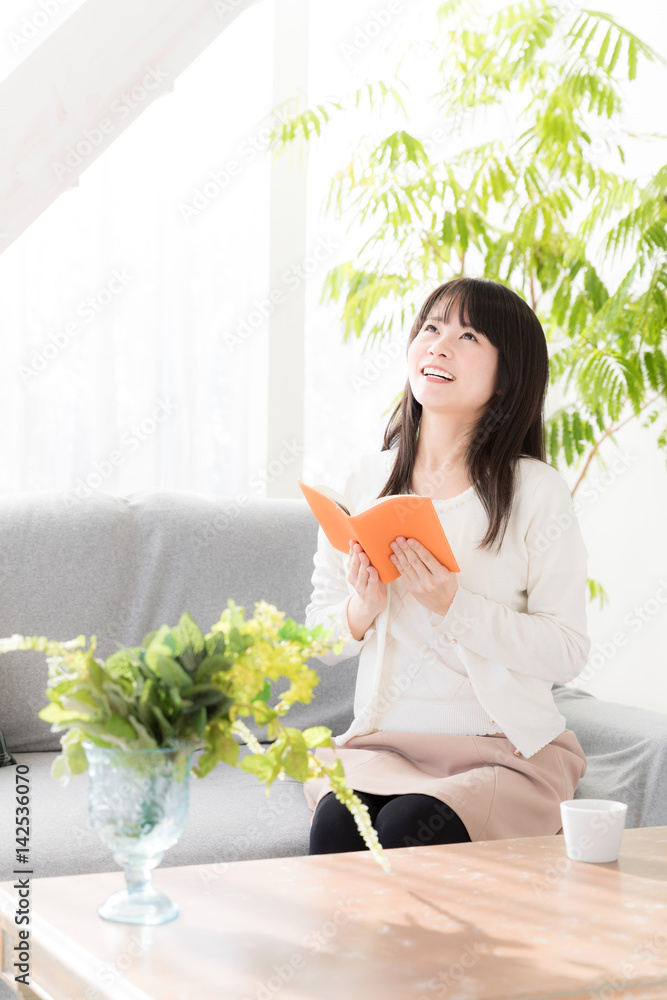 attractive asian woman relaxing in living room