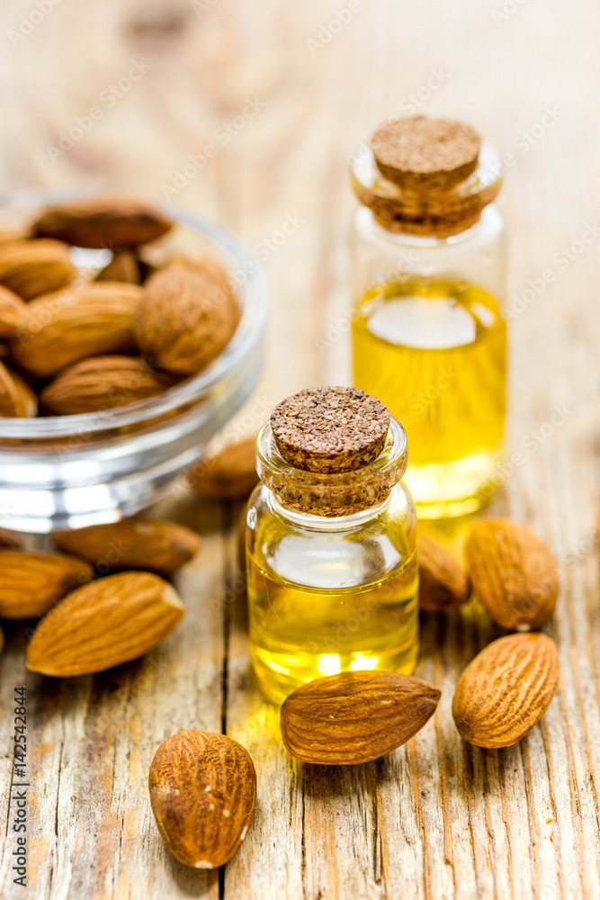 cosmetic and therapeutic almond oil on wooden background