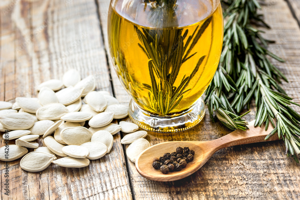 natural oils concept with pumpkin seeds on table background