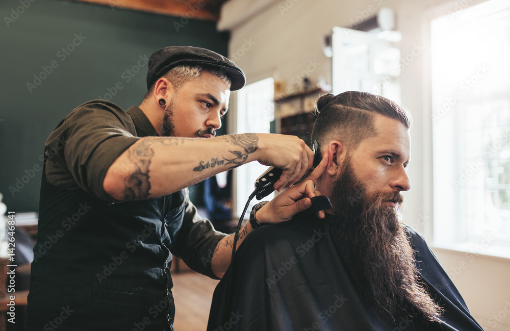 Man getting trendy haircut in barbershop