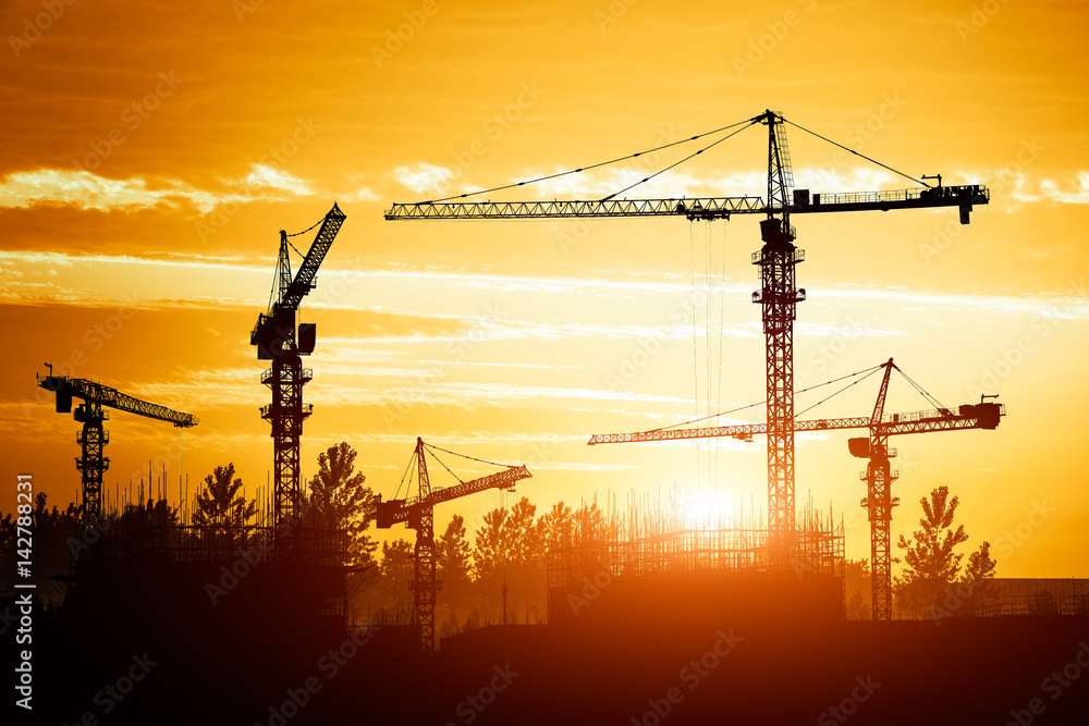 Crane and building construction site at sunset