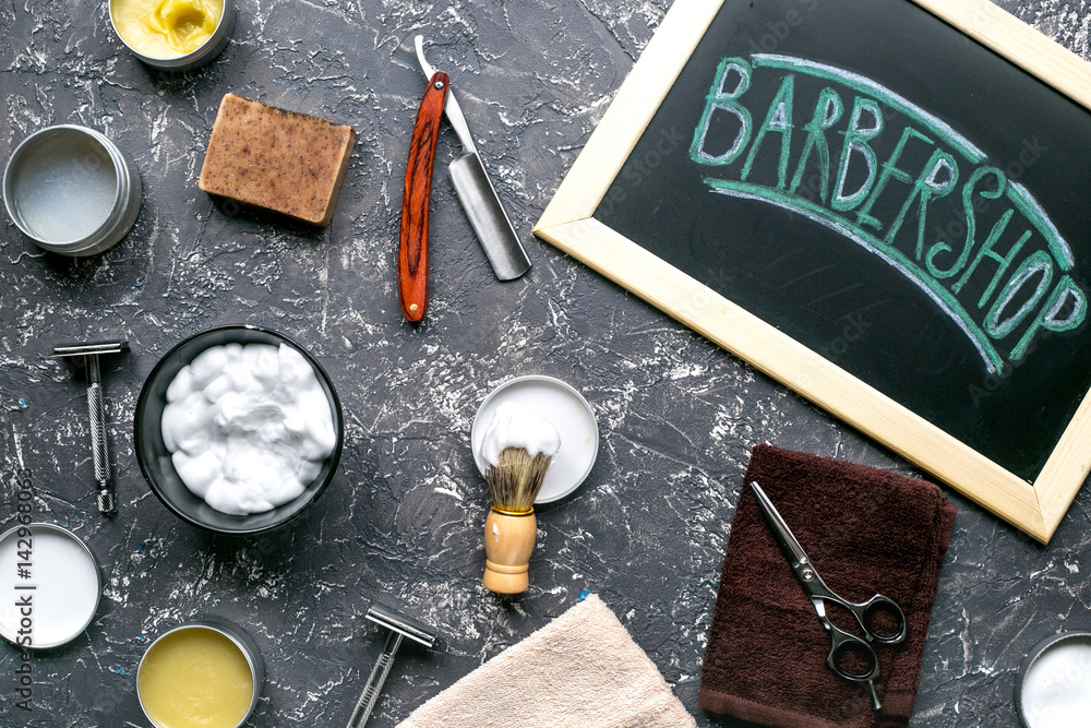 Tools for shaving in barbershop on workplace background top view