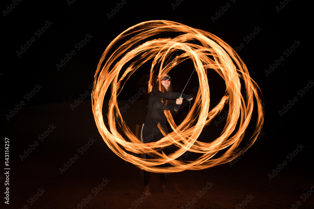 Dancer with flaming fire pois after dark.