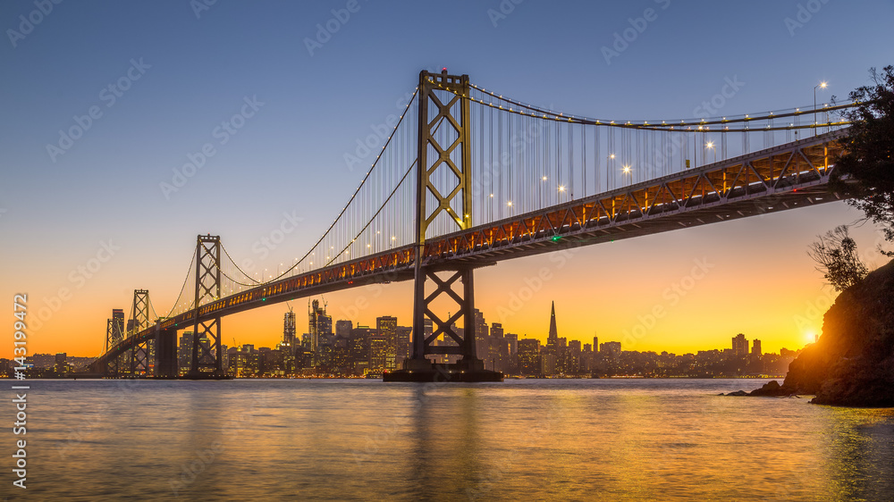 San Francisco skyline with Oakland Bay Bridge at sunset, California, USA