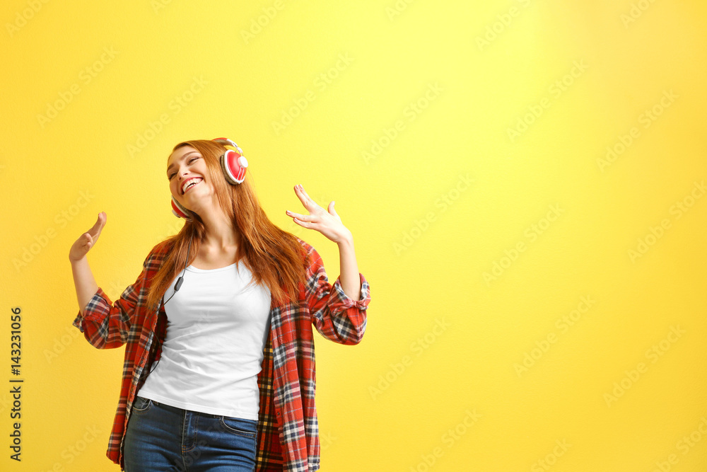 Beautiful young woman listening to music on color background