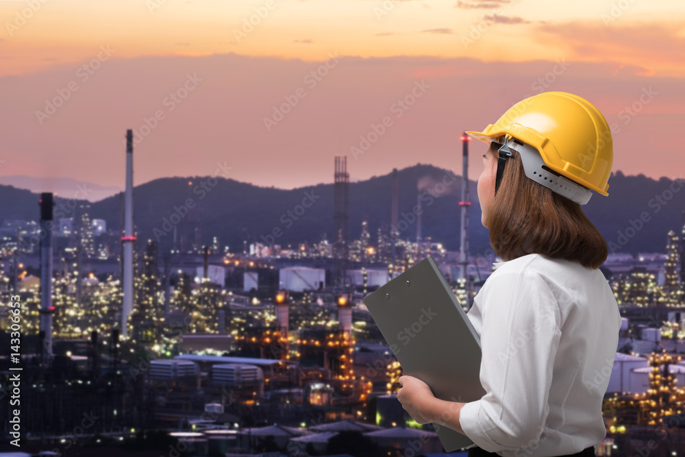 Female engineer wearing safety helmet inspects pipeline industry site