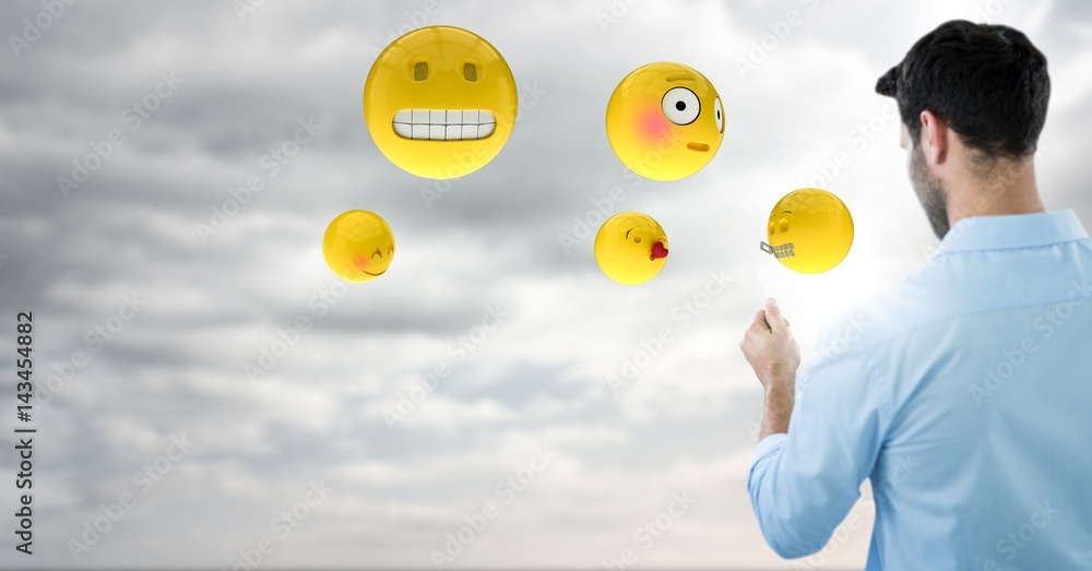 Back of man with emojis and flare against sky with clouds