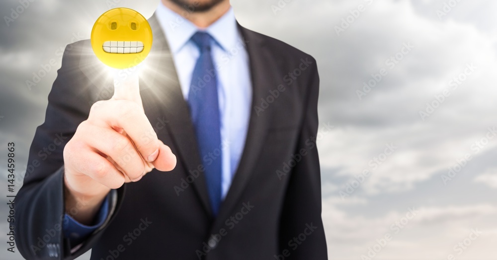 Business man pointing at emoji with flare in cloudy sky