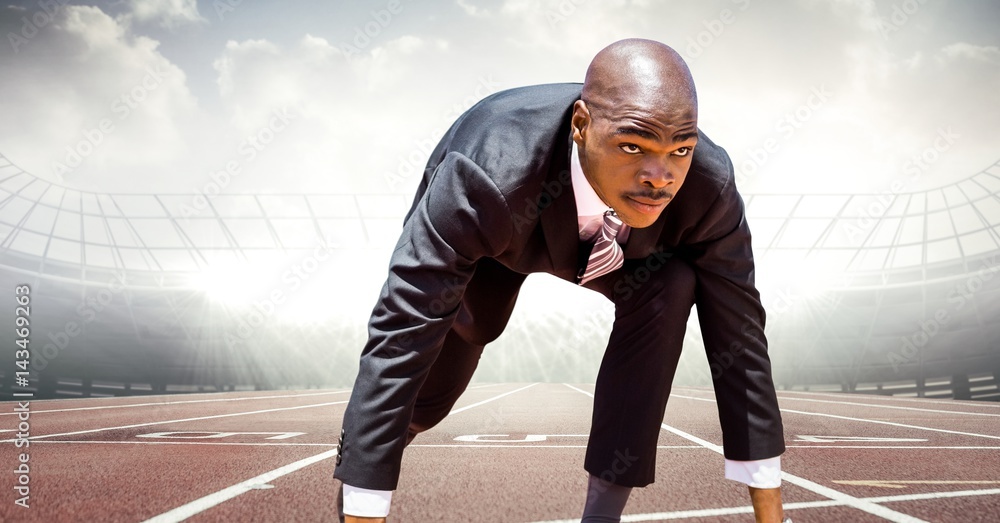 Business man at start line on track against flares