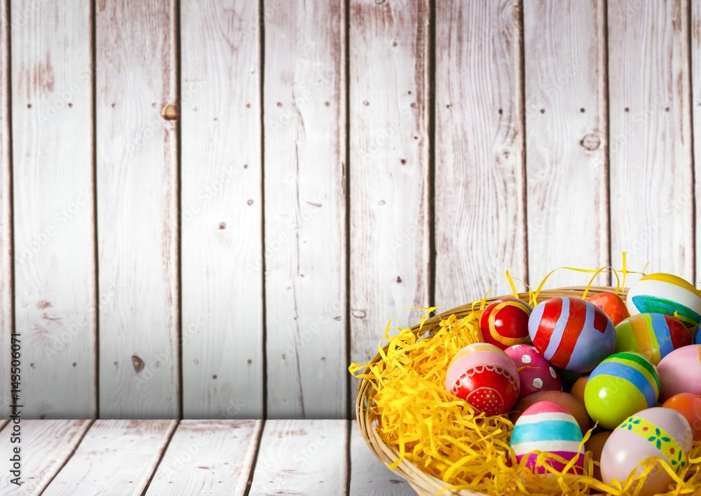 Basket with Easter eggs with wood background