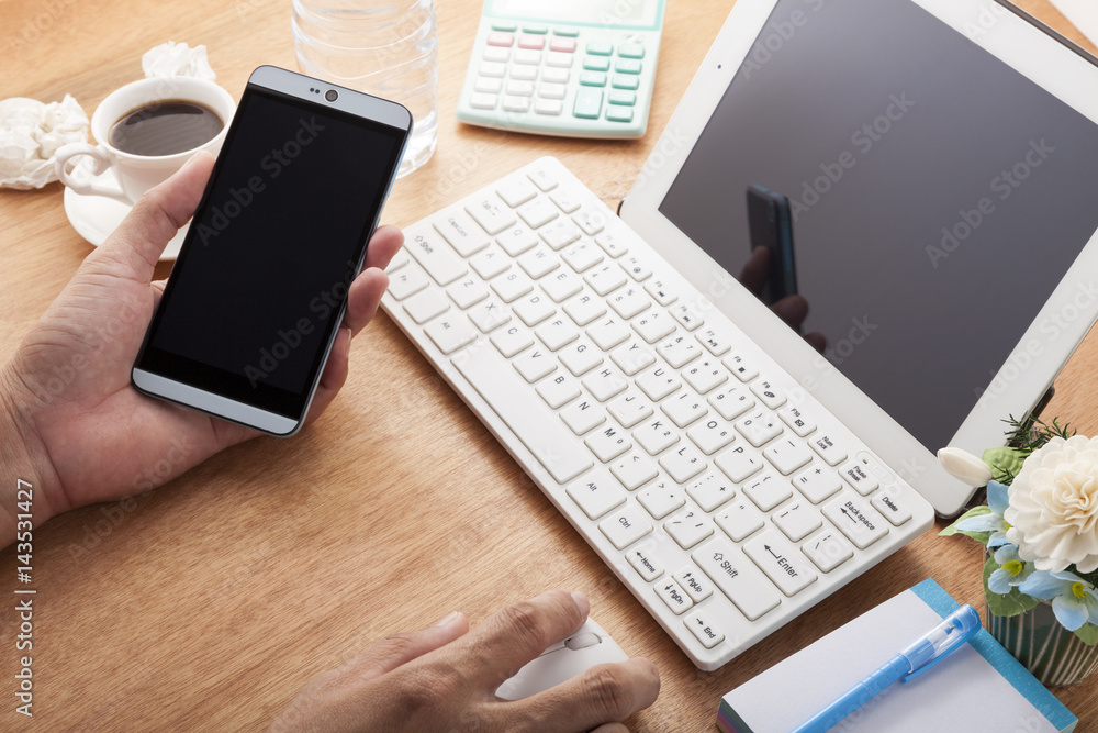 hands using cell phone and laptop on desk wood and Business workplace, business objects.