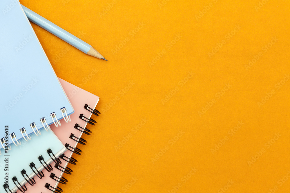 pencil and notebook on colorful paper background