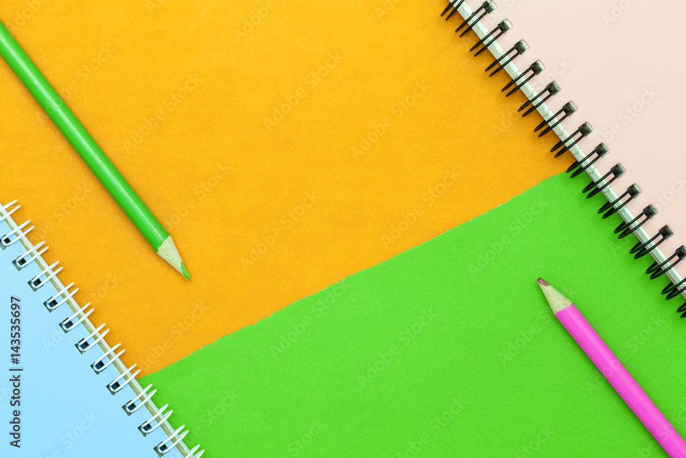 pencil and notebook on colorful paper background