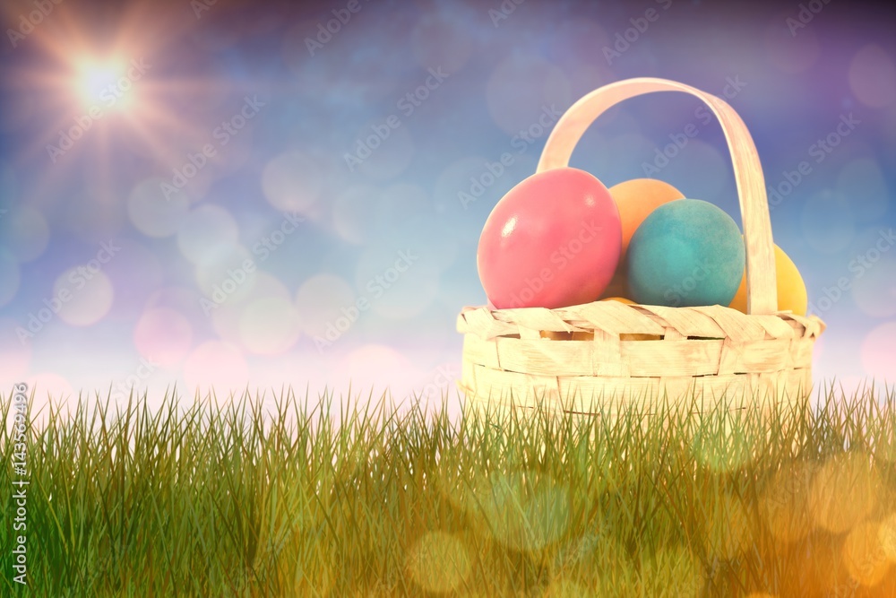 Composite image of easter eggs in wicker basket