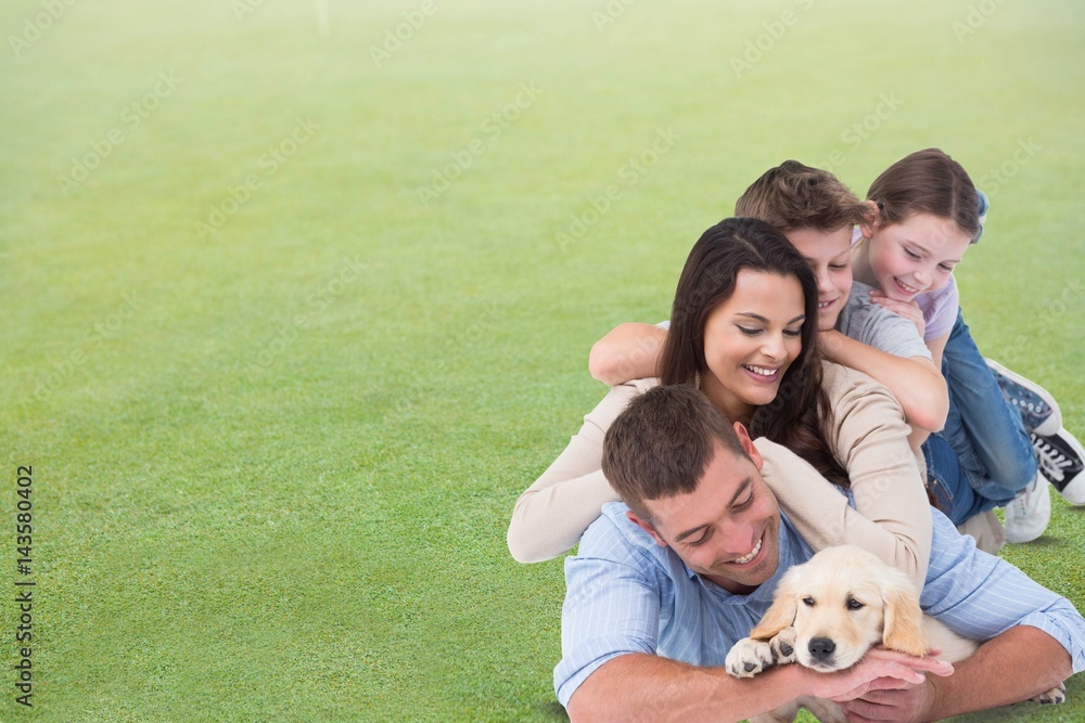 Happy family with dog lying on grass