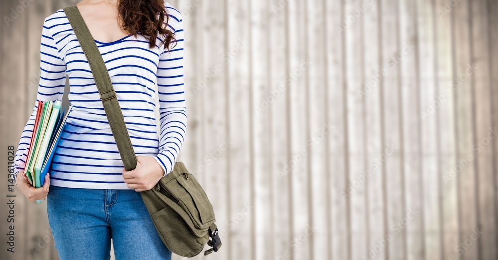 Woman with books and bag against blurry wood panel