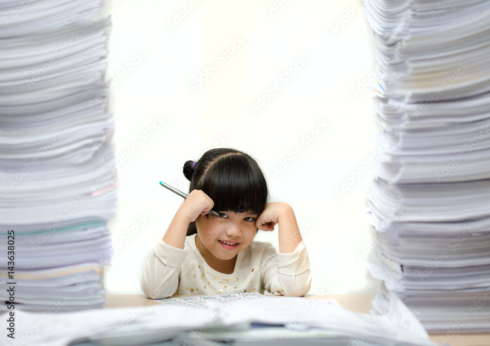 Little asian cute girl doing homework. big burden on students. overloaded child