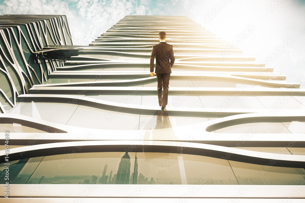 Businessperson walking up glass building