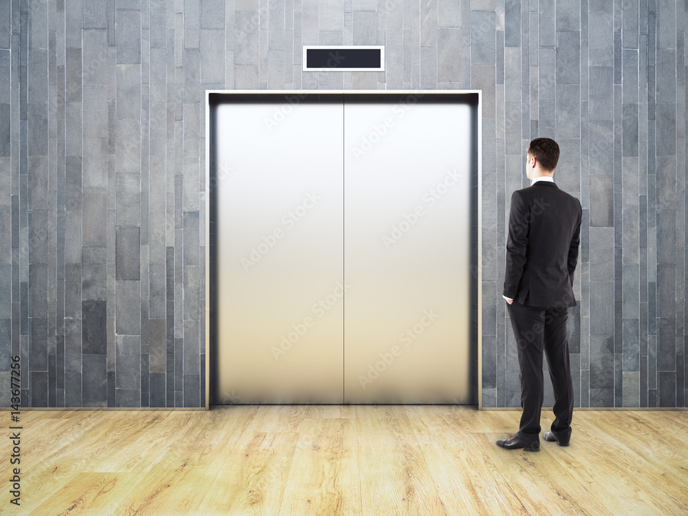 Thoughtful man looking at elevator